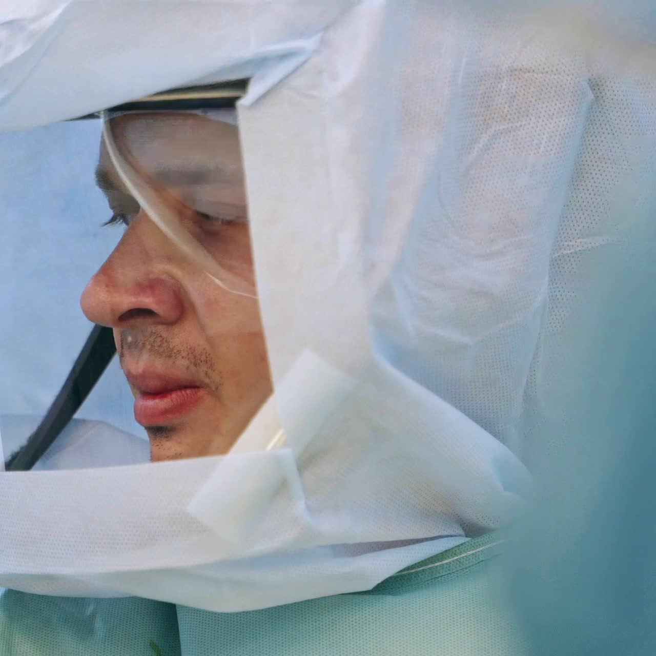 Young male doctor wearing protective suit at surgery room. Portrait of a surgery specialist close up