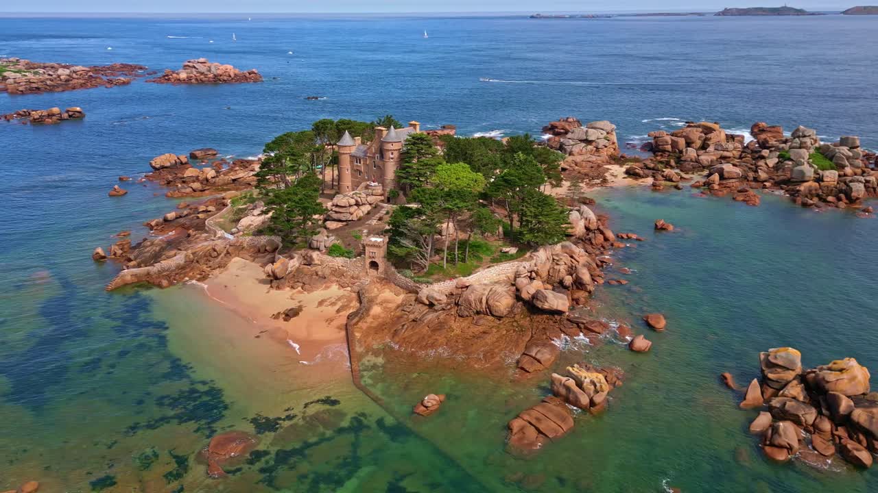 Panoramic panning drone movement near the beautiful Costaérès Castle surrounding shallow turquoise seawater, Trégastel, Brittany, France.
