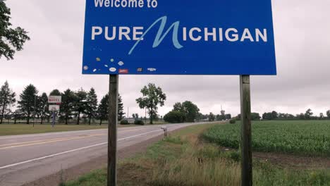 Welcome-to-Pure-Michigan-sign-on-the-state-line-of-Michigan-and-Indiana-with-video-tilting-up