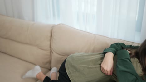 close relationship. affectionate young mom and daughter hug on couch home