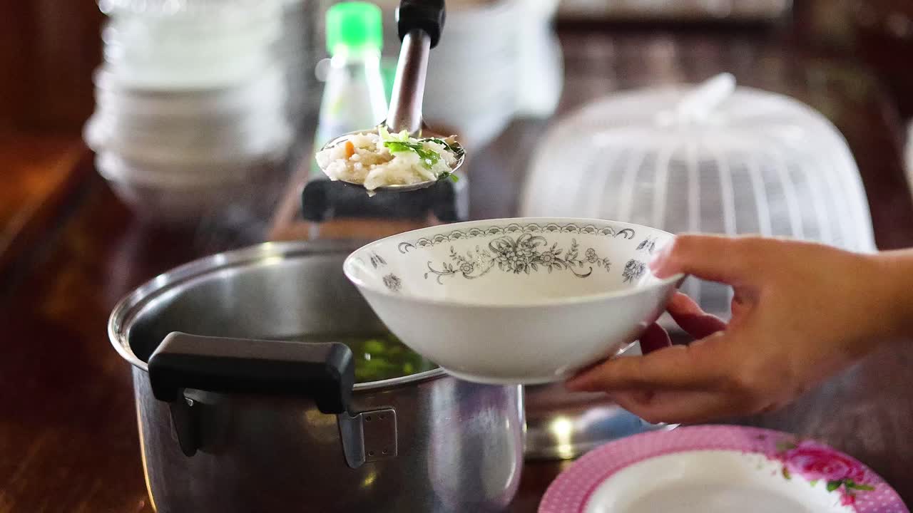 Person ladling boiled rice into a bowl