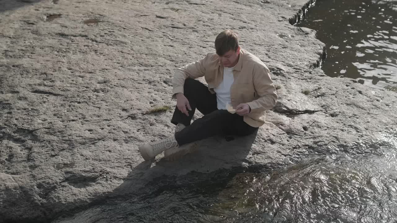 강에서 종이 배, 연못에서 항해하는 오리가미 선박, 물 위에서 종이 선박을 발사하고 밀어내는 남자