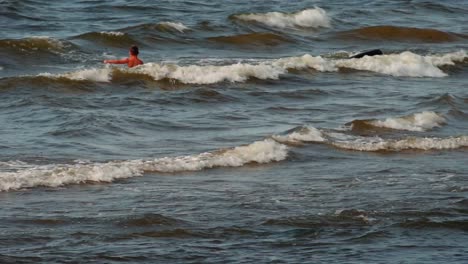 un niño nada solo en el mar con fuertes olas
