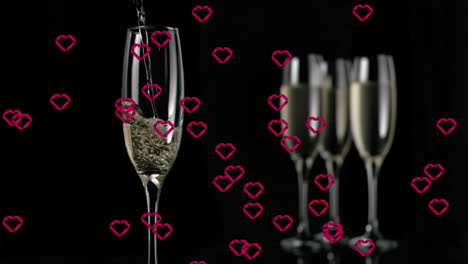 pouring champagne into glass with pink heart animation over black background