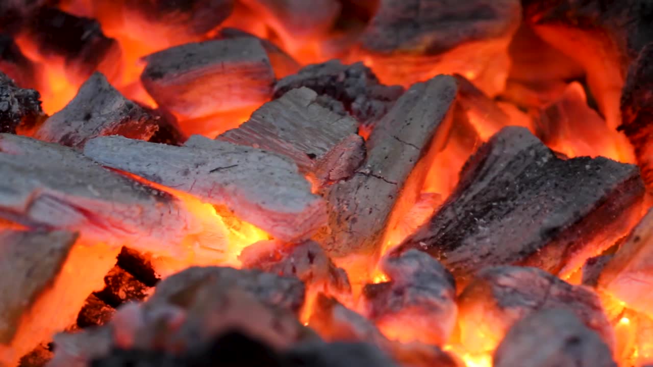 un primer plano de la quema de carbón caliente en una parrilla brasas rojas y llameantes, concepto de parrilla