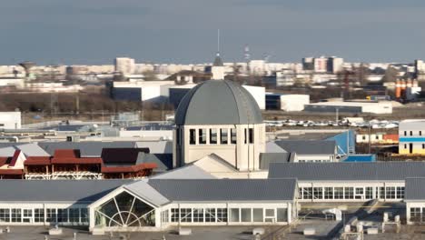 Aerial-tracking-shot-showing-cupola-of-shopping-center-area-in-Bucharest,-Romania