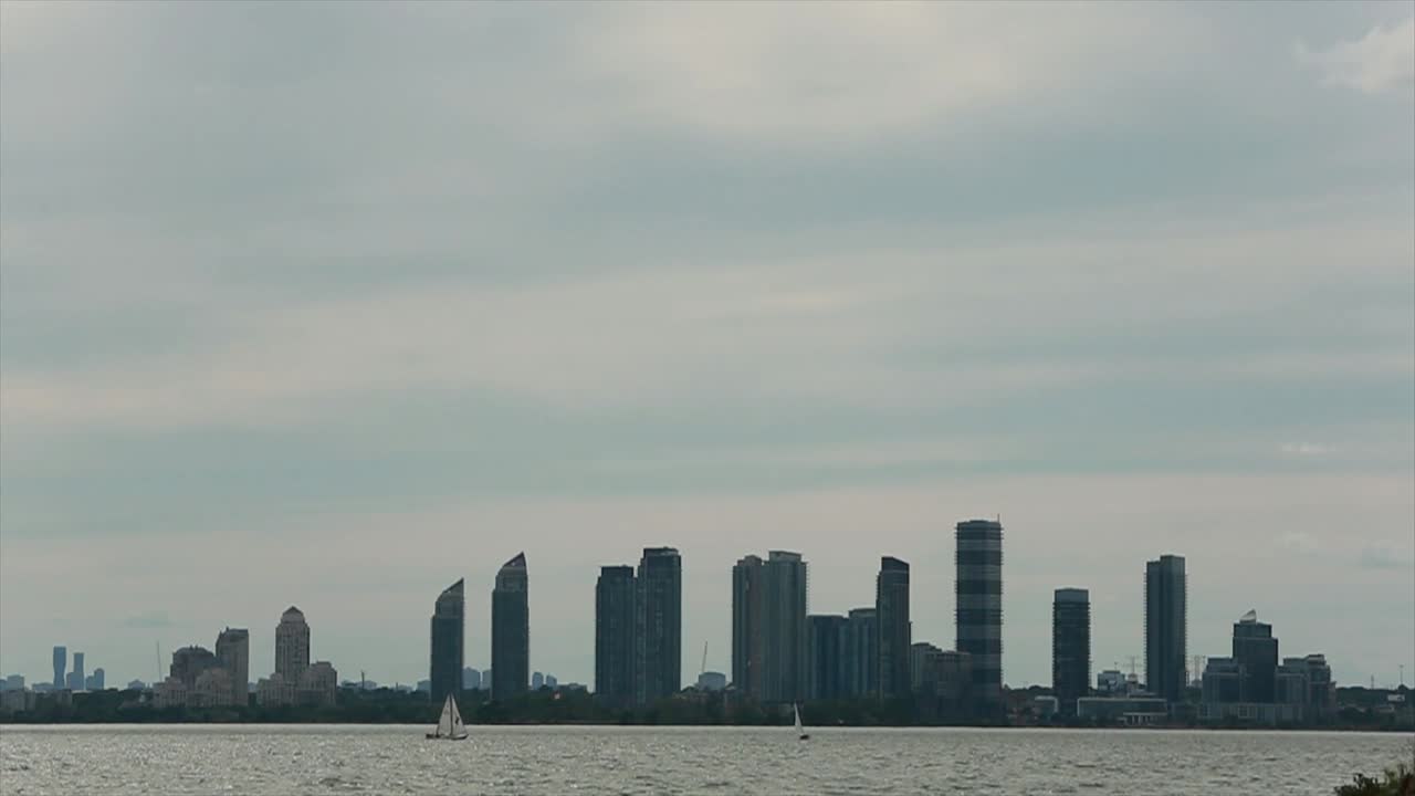 Boats in water with city in background.
