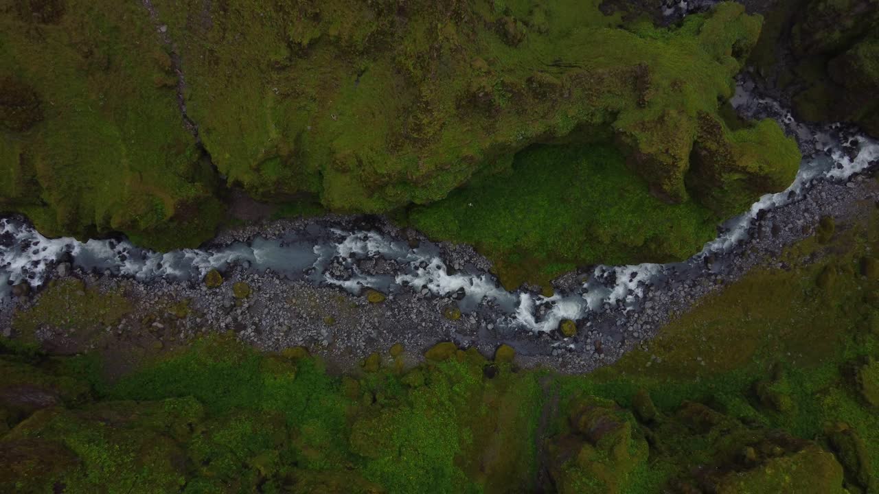 río horizontal que se eleva con paredes verdes del cañón a ambos lados del cañón mulgljufur islandia
