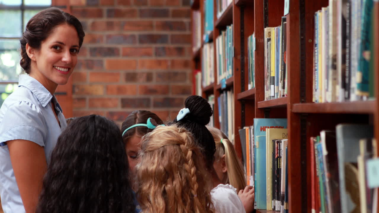 Pupils talking with their teacher in the library