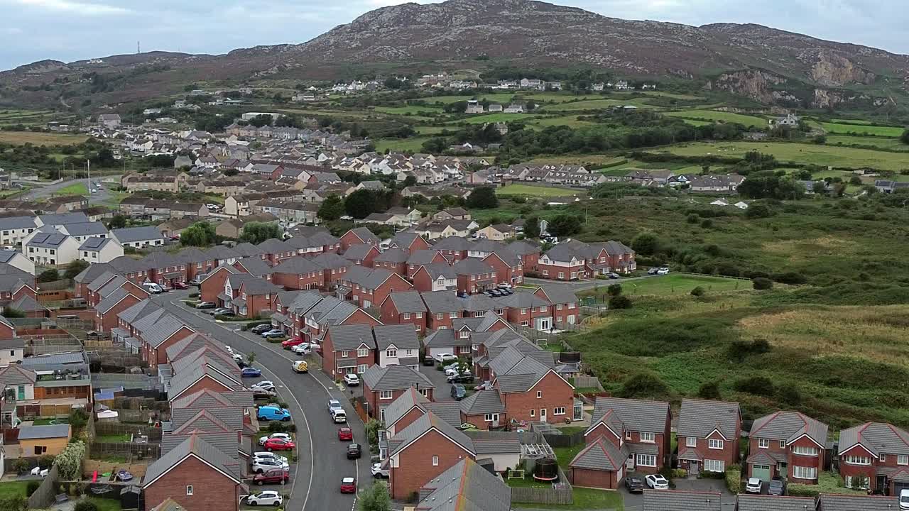 Welsh townhouse modern property aerial view circling across rocky mountain neighbourhood