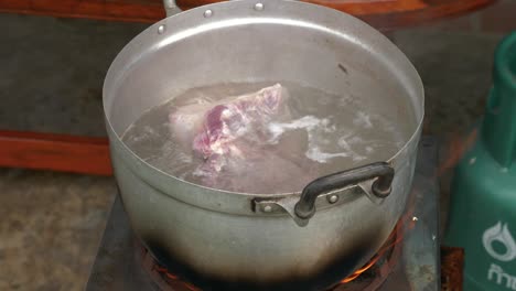 boiling meat in aluminum pot outdoors