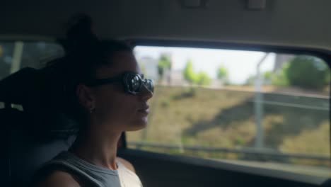 young woman traveling in car, looking out window
