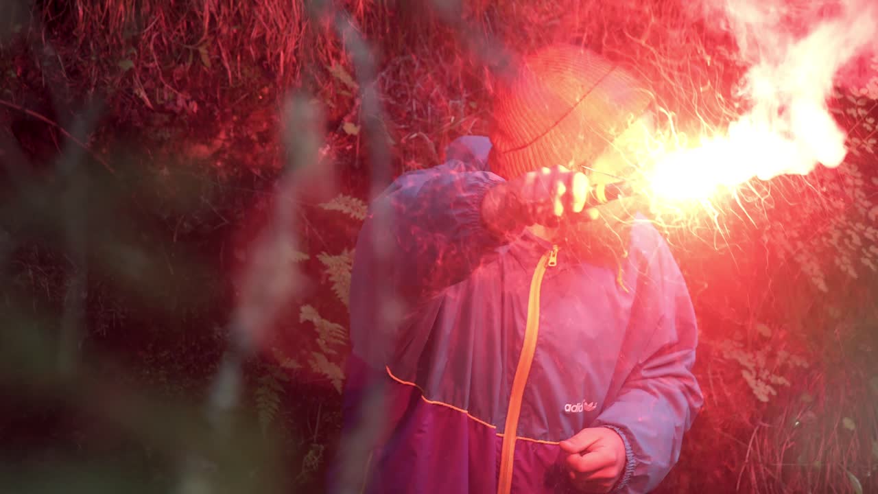 hombre con llamarada roja en el bosque