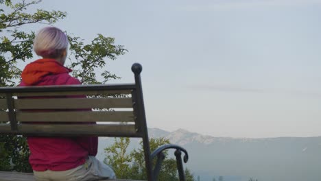 woman sitting on a bench overlooking mountains