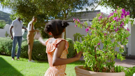 girl exploring garden with diverse family, enjoying sunny vacation day