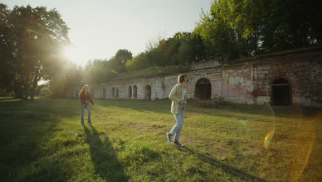 couple walking in a park near old ruins at sunset