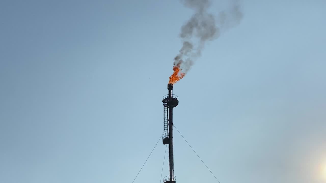 맑고 푸른 하늘에 불타는 가스 플레어의 근접 망원, 축소