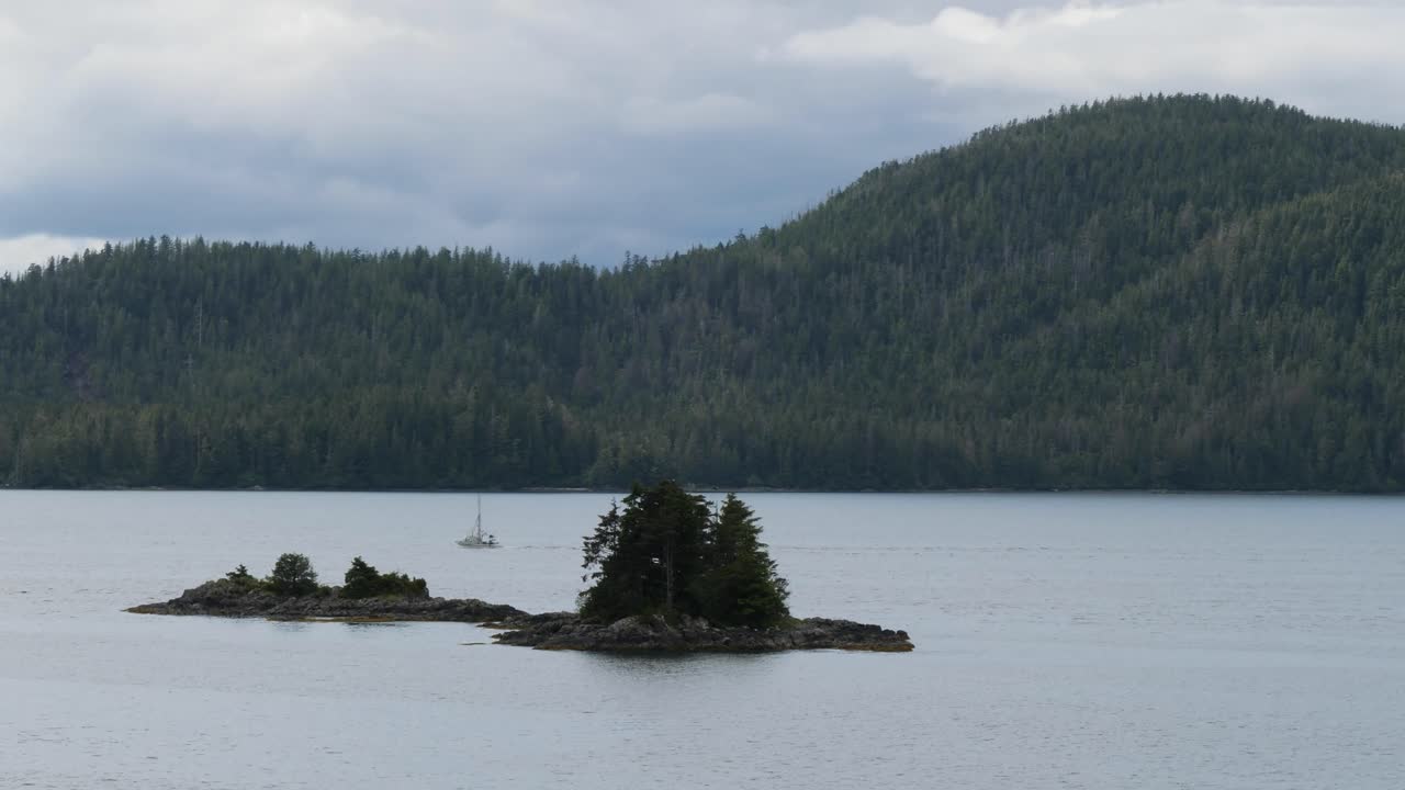Small boat sailing among the small rocky islands near Sitka, Alaska.