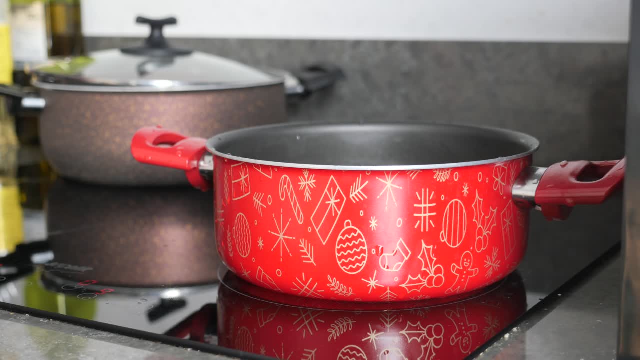olla roja con diseño de navidad en la estufa