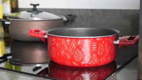 red pot with christmas design on stovetop