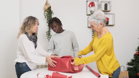 a family wrapping christmas gifts together