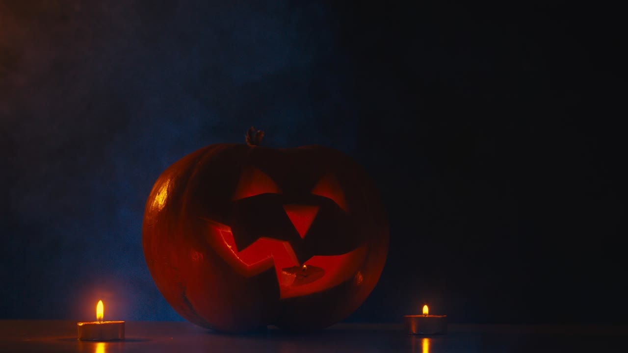 cinemagraph - cu halloween tallado calabaza jack-o-lanterna con velas, niebla en el fondo