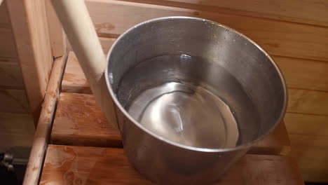 vista de cerca del agua que se saca de un recipiente de acero que contiene agua para cocinar en la cocina