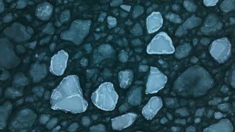 top down shot of large ice floes gently moving in the waves of the sea