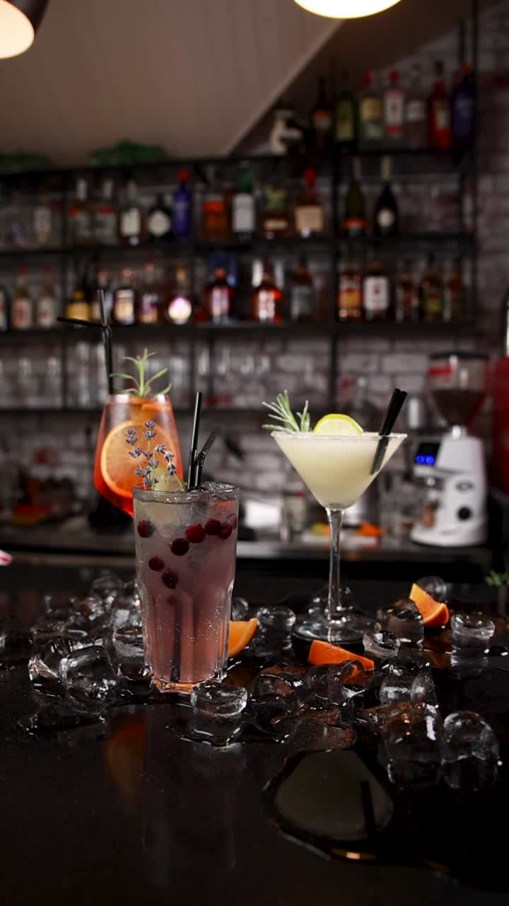 Three refreshing cocktails on a bar counter