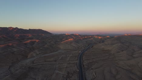 Vista-Aérea-De-La-Puesta-De-Sol-En-El-Horizonte-Sobre-La-Carretera-Rcd-A-Través-Del-Paisaje-Dramático-Remoto-De-Baluchistán