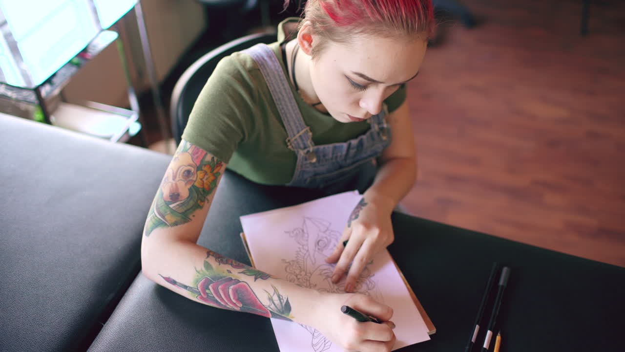 artista del tatuaje trabajando en un diseño