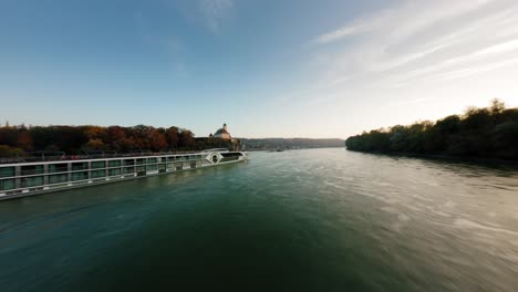 FPV-flies-parallel-to-Danube-cruise-ship-towards-Castle-Schönbühel-during-a-beautiful-sunset