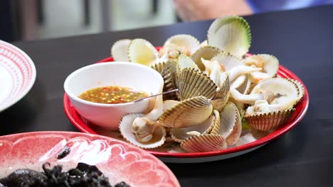 freshly boiled ark clams served with spicy dipping sauce in phuket