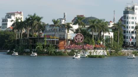 people enjoying sailing on swan peddle boats, truc bach lake, hanoi