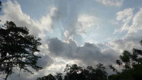 timelapse looking up at stratocumulus and altostratus clouds merging over the sun creating beams of light