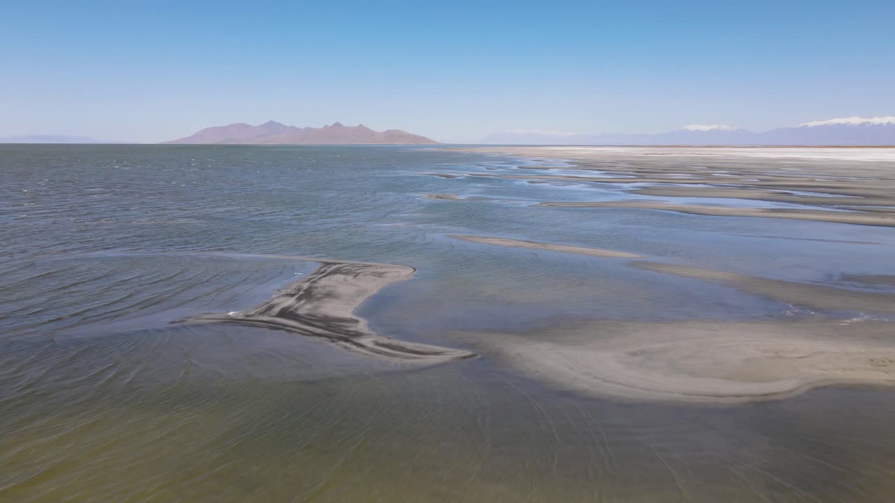 A 4K drone shot over the perfectly flat Bonneville Salt Flats, found west of the Great Salt Lake, in western Utah, with a shallow layer of standing water flooding the vast salt plain&rsquo;s surface