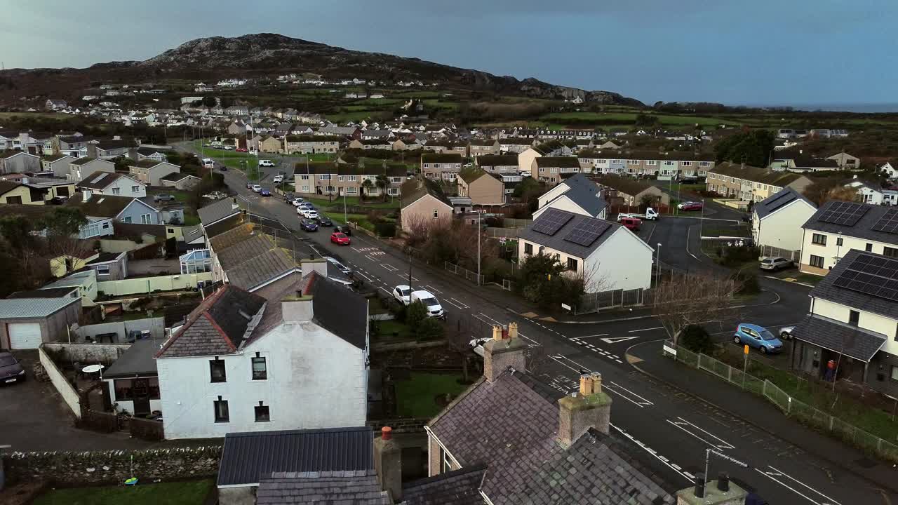 Rainy Holyhead homes aerial view rising over small island town neighbourhood mountain real estate