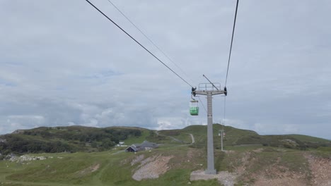 passing green cable car gondola sightseeing transportation moving up scenic mountain valley hillside