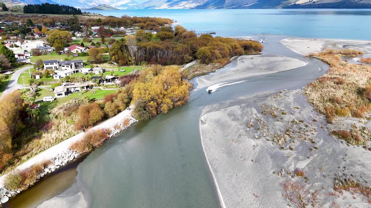 Aerial footage captures Glenorchy's serene riverbend, showcasing vibrant autumn foliage and tranquil waters under clear skies