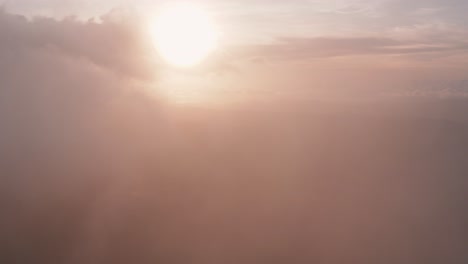 Incredible-aerial-view-flying-through-light,-heaped-up-and-wispy-clouds-in-golden-sunset,-sunrise