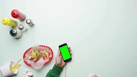 Vista-Superior-Del-Hombre-Conectando-Auriculares-Al-Teléfono-Móvil-En-El-Restaurante-De-Comida-Rápida-American-Diner-Con-Las-Manos-Desde-Arriba---Dragón-épico-Rojo