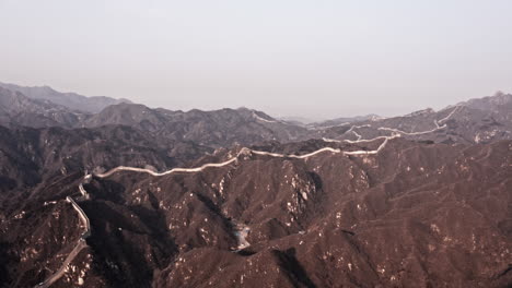 aerial shot of the great wall of china winding through mountains