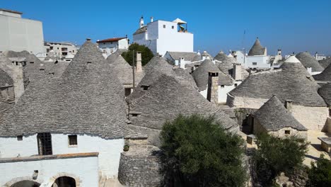 drone aéreo cerca de trullis, casas pequeñas, cabañas de piedra encaladas con techo cónico