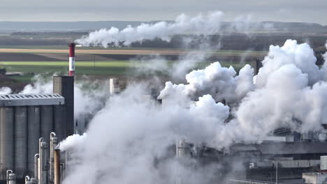 a sweeping aerial shot captures the juxtaposition of nature and industry, fields