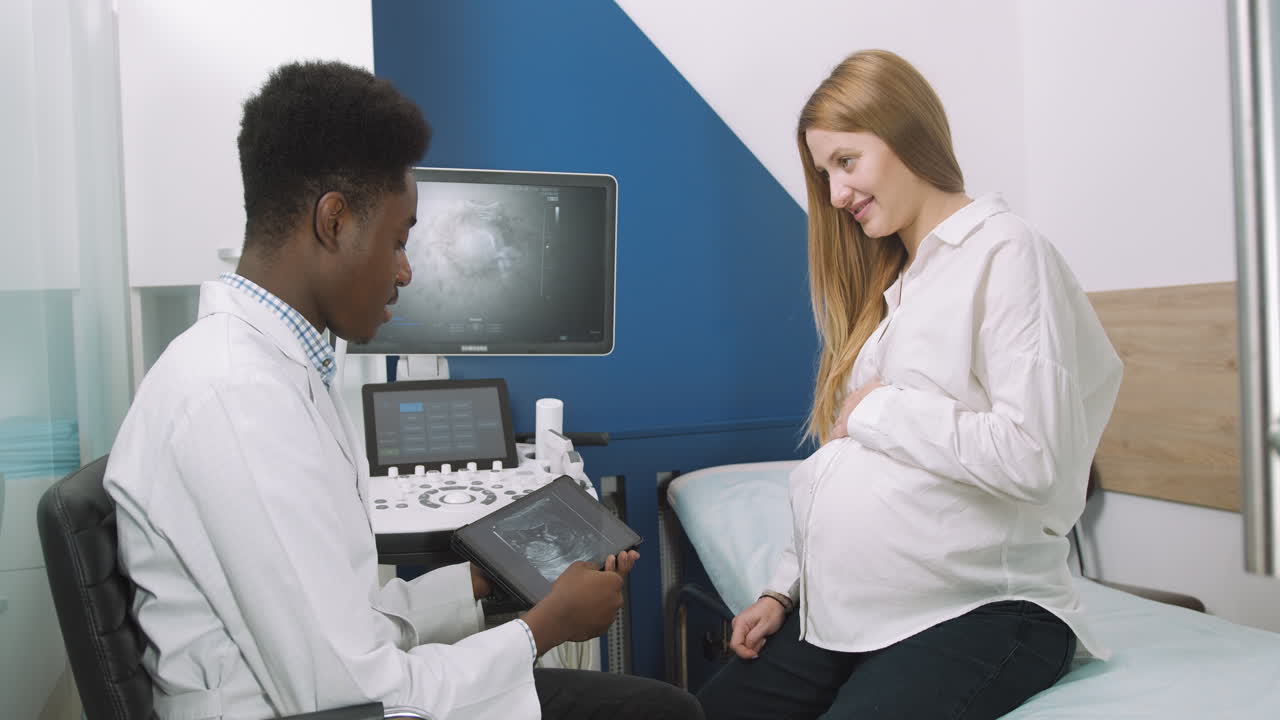 Doctor showing ultrasound scan to pregnant woman