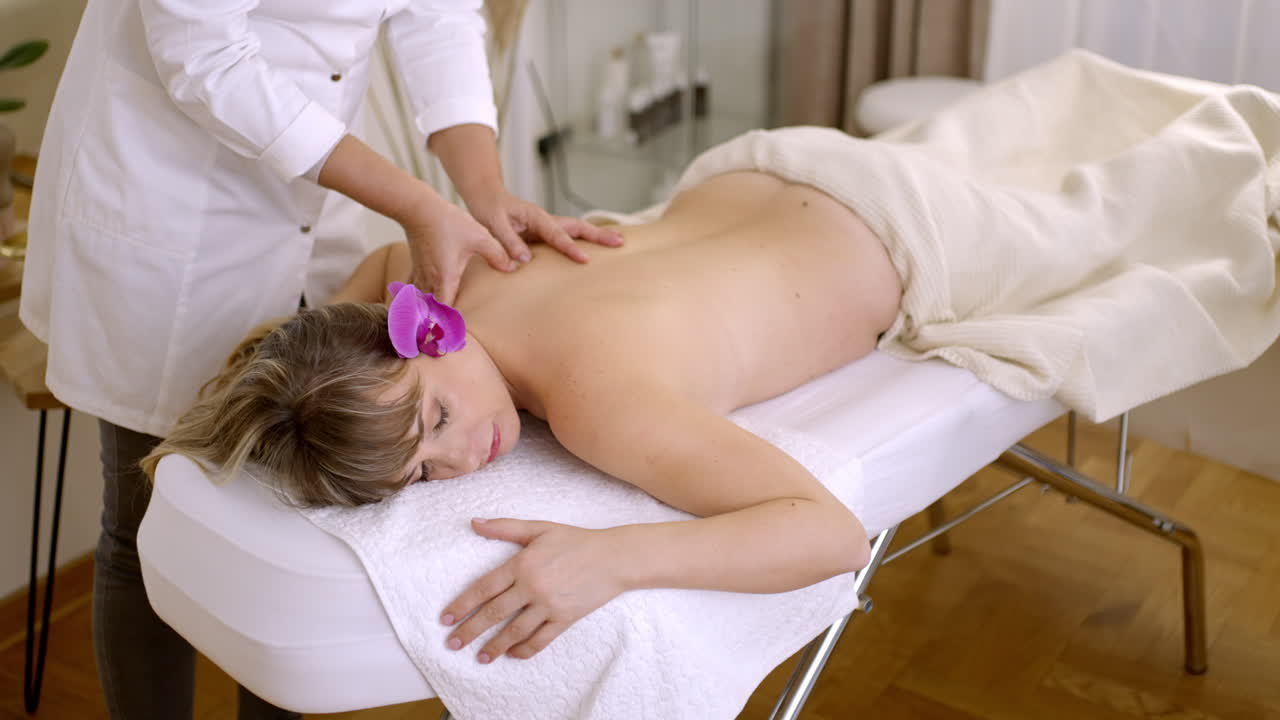 una mujer recibiendo un masaje de espalda en un spa.