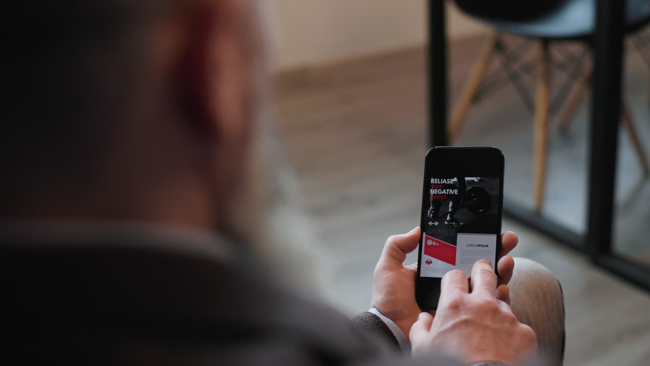 vista trasera de un hombre usando un teléfono inteligente