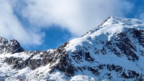 toma panorámica de drones, de nubes que se mueven rápidamente en la cima de montañas nevadas picos tomados de telelens de drones - no clasificados