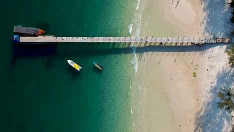 Vista-Aérea-De-Arriba-Hacia-Abajo-De-La-Hermosa-Playa-De-Arena-Blanca-Y-El-Muelle-En-La-Playa-4k,-Koh-Rong,-Camboya