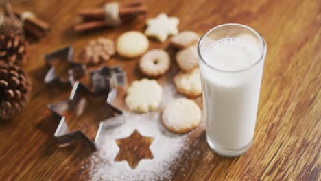 Video-Von-Weihnachtsdekorationen-Mit-Einem-Glas-Milch-Und-Keksen-Auf-Holzhintergrund